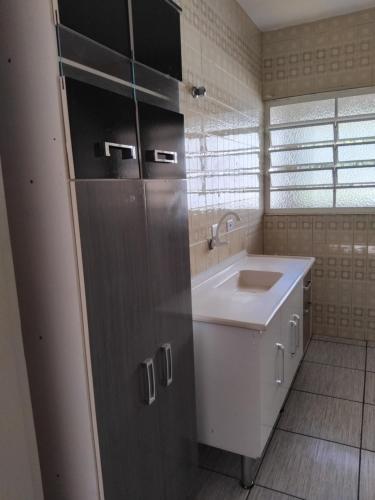 a white bathroom with a sink and a counter at Apartamento da mel in Águas de Lindóia