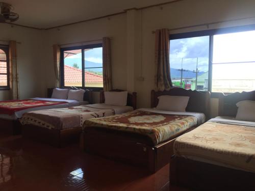 a room with four beds in a room with windows at Oudomphone Guesthouse 2 in Ban Houayxay