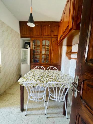 a kitchen with a table with chairs and a refrigerator at Dar Misk Elil in Bizerte