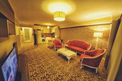 a living room with a couch and chairs and a tv at My Suit Residence & Hotel in Samsun
