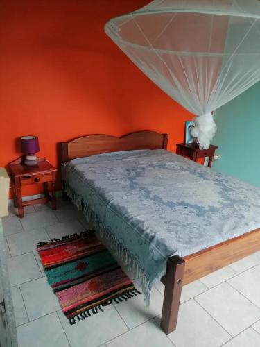 a bedroom with a bed with a mosquito net on it at Charmante maison près de Rivière-Pilote - 65 m² avec terrasse. in Rivière-Pilote
