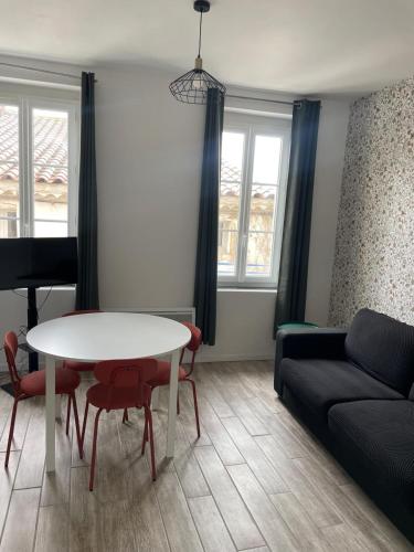 a living room with a table and a couch at Les Halles d'Isa et Thomas in Narbonne
