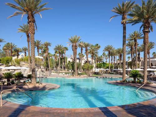 a large swimming pool with palm trees in a resort at The Westin Mission Hills 1BR Apartment with Resort Access in Rancho Mirage