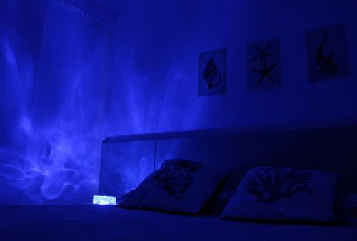 a dark room with a bed with blue lighting at Apto de duas suítes com vista mar - 100 metros da praia em Canasvieiras in Florianópolis