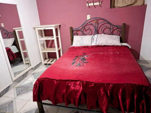 a bedroom with a red bed with a red blanket at Tipo Host para 16 personas in Tarija