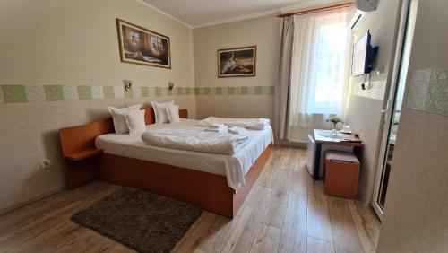 a small bedroom with a bed and a window at Pensiunea Veronica in Baile Felix