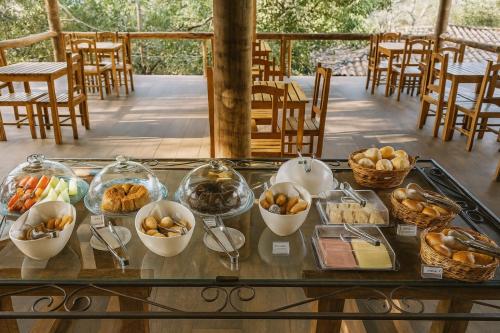 a buffet of food on a table with bowls of food at Pousada Bella Vista in Serra do Cipo