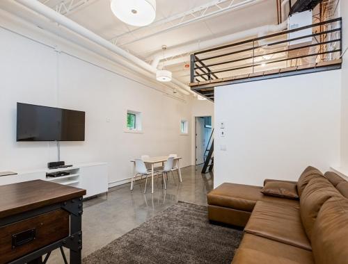 a living room with a couch and a flat screen tv at The Modern Loft Haven in Calgary