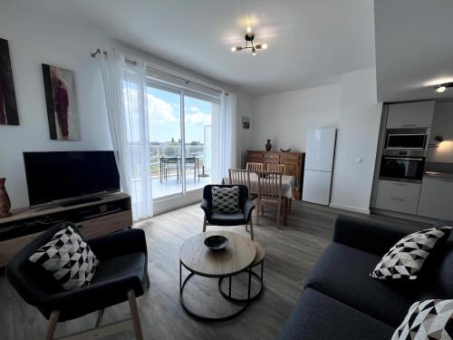 una sala de estar con un sofá y una mesa en Le 30 - Vannes station - 4 pers parking, en Damgan