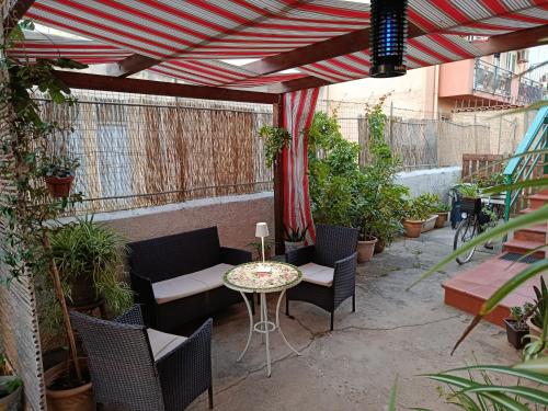 un patio con tavolo, sedie e piante di Appartamentino Cinisi a Cinisi