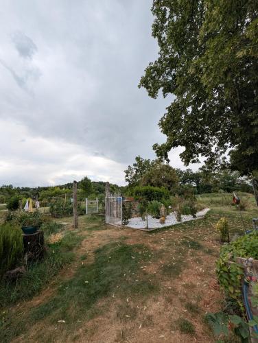 un jardin avec un portail dans un champ dans l'établissement Chambre d'hôtes, à Briatexte