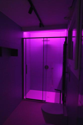 a purple bathroom with a shower with a glass door at Essenza in Campomarino