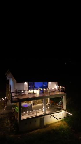 a night view of a house with a deck with lights at Glamping Pedro in San Gil