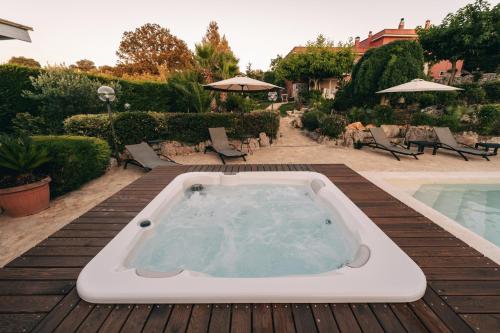 a hot tub sitting on a deck next to a pool at Villa Giacomina in Fasano