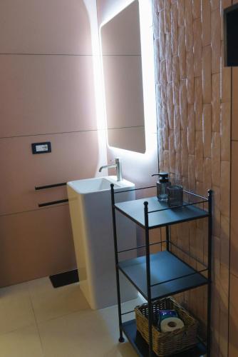 a small bathroom with a sink and a mirror at Essenza in Campomarino