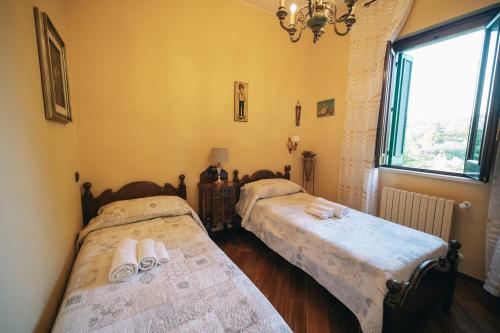 two beds in a room with a window at Villa Giacomina in Fasano