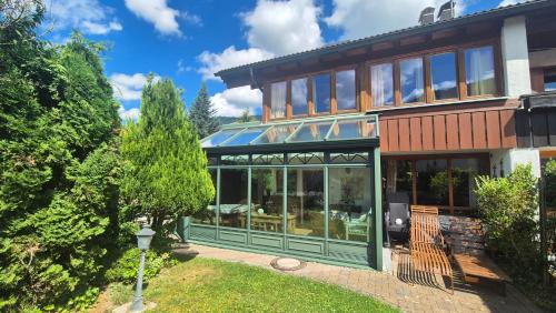 a large house with glass doors and windows at Konstanzer Bergblick mit Wintergarten in Oberstaufen