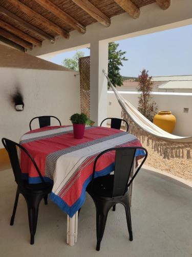 a dining room table with a red and blue blanket on it at Pátio do Forno in Mértola