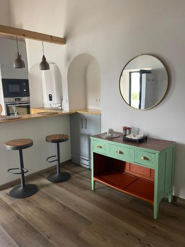 a kitchen with a green dresser and a mirror at Pátio do Forno in Mértola