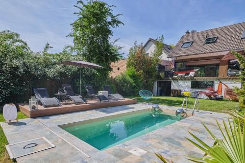- une piscine dans une cour avec des chaises et un parasol dans l'établissement Paris Garden River residence, à Créteil