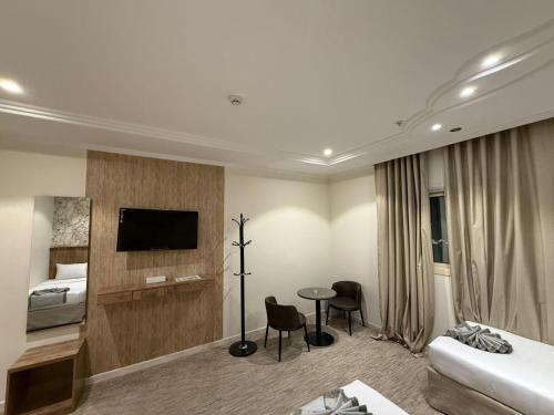 a hotel room with a bed and a tv at فندق الخلفاء الماسي الفندقية in Makkah