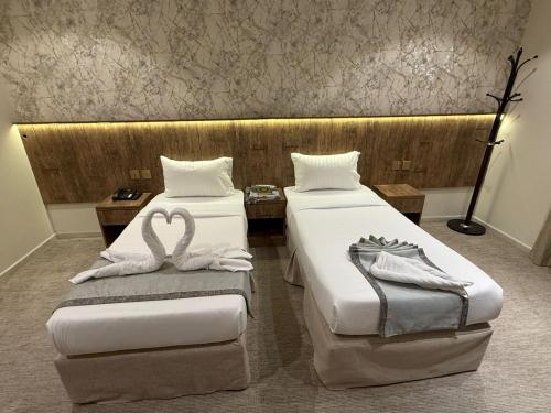 two beds in a hotel room with towels on them at فندق الخلفاء الماسي الفندقية in Makkah