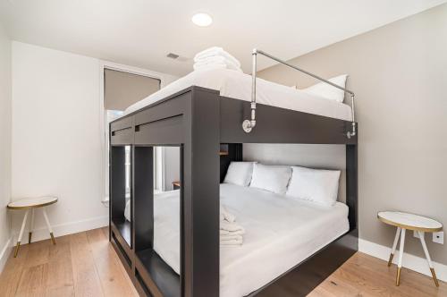 a black bunk bed in a room with two stools at The Saddlery-Playlist-2 Units-Walk to Broadway in Nashville