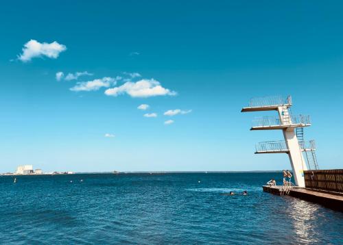 a pier with people swimming in the water at Toppmodern familjelägenhet nära Kalmar slott och långviksbadet in Kalmar