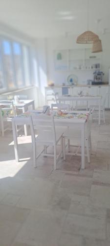 a group of white tables and chairs in a room at B&B La Loggia in Lonato del Garda