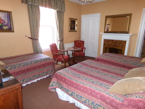 a hotel room with two beds and a fireplace at Averon Guest House in Edinburgh