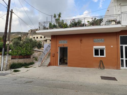 an orange building with a balcony on top of it at Despoinas House in Plátanos
