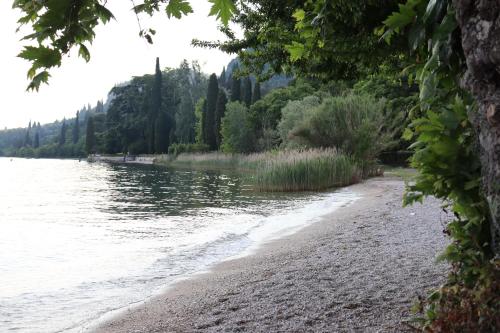 una spiaggia sabbiosa accanto a un bacino d'acqua di Monika Holiday 5 Lake Garden a Garda