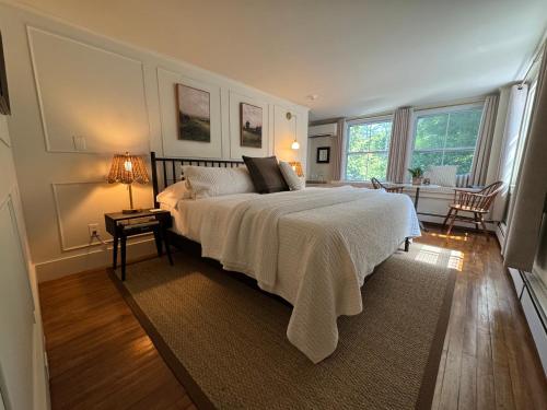 a bedroom with a bed and a table with a lamp at Hideaway Inn Maine in Camden