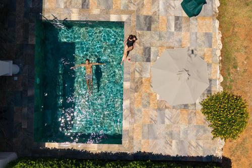 a man and woman swimming in a pool with an umbrella at KRESTEN ROYAL Euphoria Resort in Kallithea Rhodes
