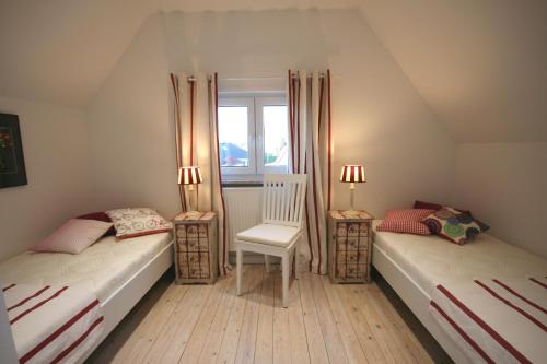 two twin beds in a room with a window at Brise 5 in Büsum