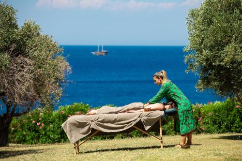 a woman in a green dress laying on a bed at KRESTEN ROYAL Euphoria Resort in Kallithea Rhodes