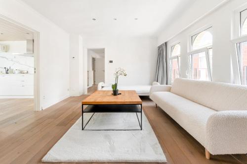 a living room with a white couch and a coffee table at Luxury apartment x big terrace in Sint-Niklaas