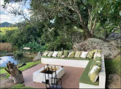 a white couch with pillows sitting on a patio at Suite Lua Crescente in Caldas