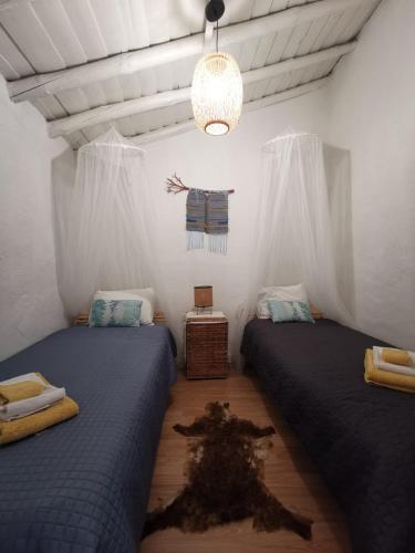 a bedroom with two beds and a chandelier at Casa Maria Anas in Pias
