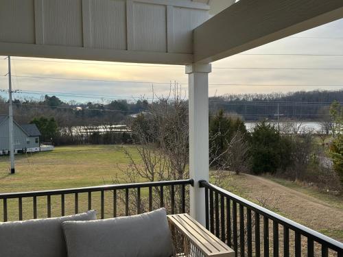 a porch with a couch and a view of a field at Tim Ford Lake House in Twin Creeks TN in Winchester