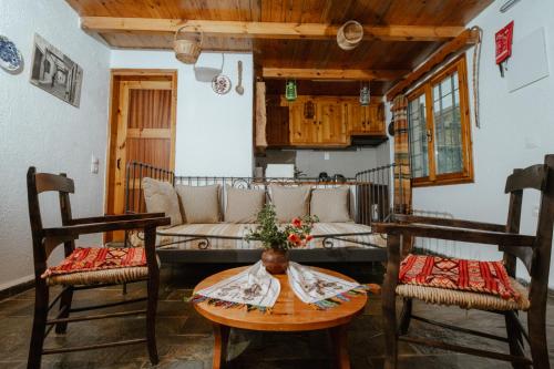 a living room with a couch and a table and chairs at Villa Kamari- Stunning Views in Kritsá