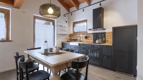 une cuisine avec une table en bois et des armoires noires dans l'établissement Sesto Senso, à Ponte di Legno
