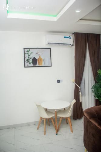 a white table and chairs in a living room at The NookHouse in Calabar