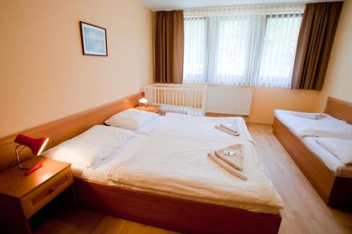 a bedroom with two twin beds and a window at Motel Svatý Kryštof in Liběchov