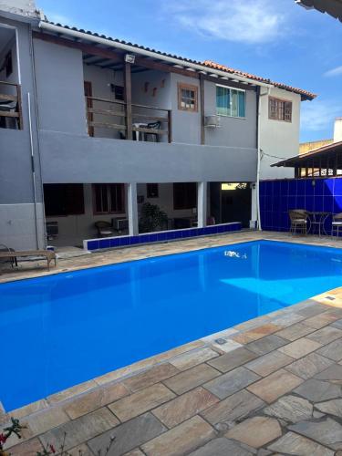a large blue swimming pool in front of a building at Pousada Recanto do Mar in Saquarema