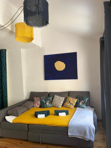 - un canapé dans le salon avec une couverture jaune dans l'établissement Studio avec terrasse sur cour, authentique, calme, à Avignon