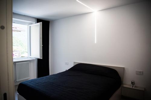 a bedroom with a black bed and a window at Villa Alisha Mountain View in Casargo