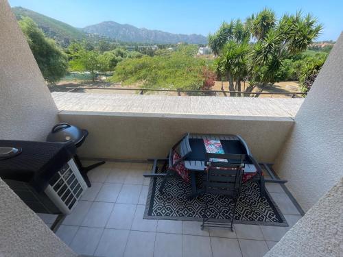 a balcony with a table and a grill on the floor at SAINT FLORENT studio terrasse 2 à 3 personnes calme avec piscine au sel in Saint-Florent