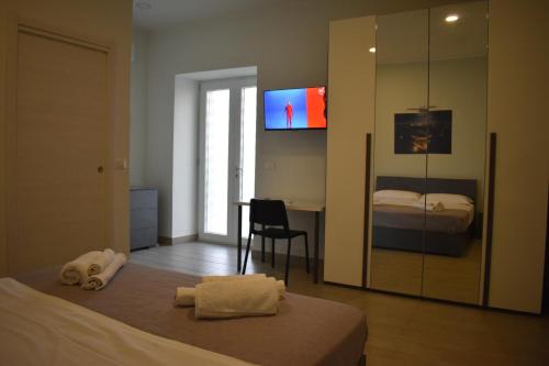 a bedroom with a bed and a desk and a television at VillART Pompei Guest House in Pompei
