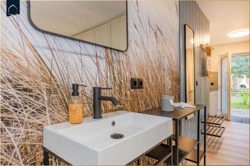 a bathroom with a white sink and a mirror at FeWo 11 "Seelenwind" in Benz